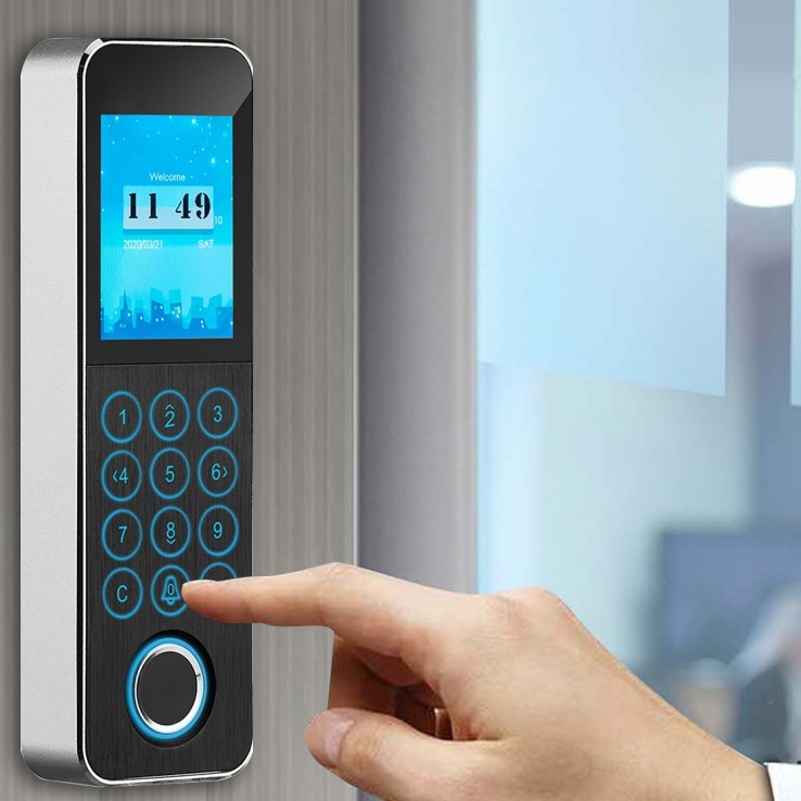 Fingerprint access terminal with a finger on the keypad, office glazing behind