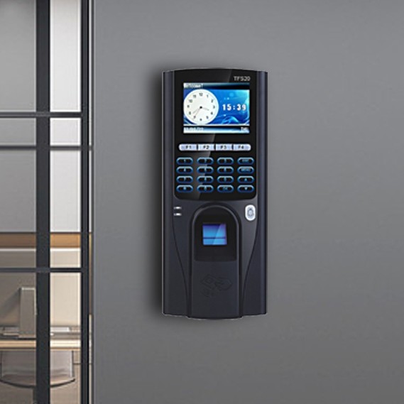 Fingerprint attendance terminal mounted on a grey wall beside an office window